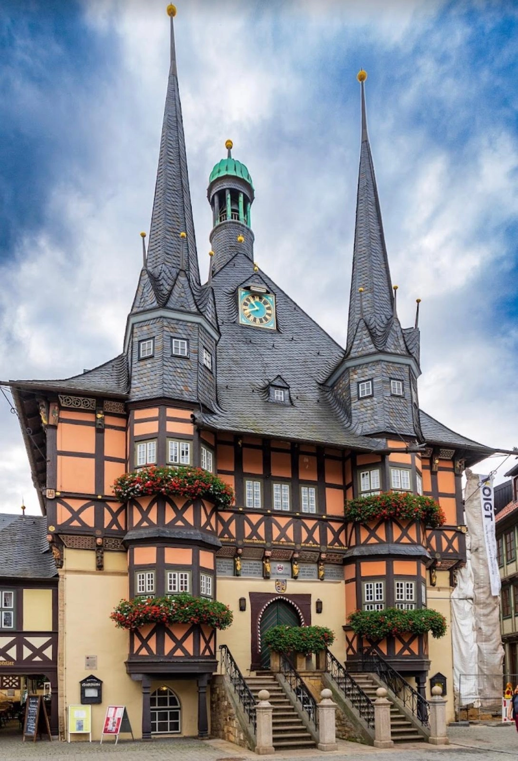 Ecklebe - Ferienwohnung - Ein traditionelles deutsches Fachwerkhaus mit zwei großen Turmspitzen und einem Uhrturm.